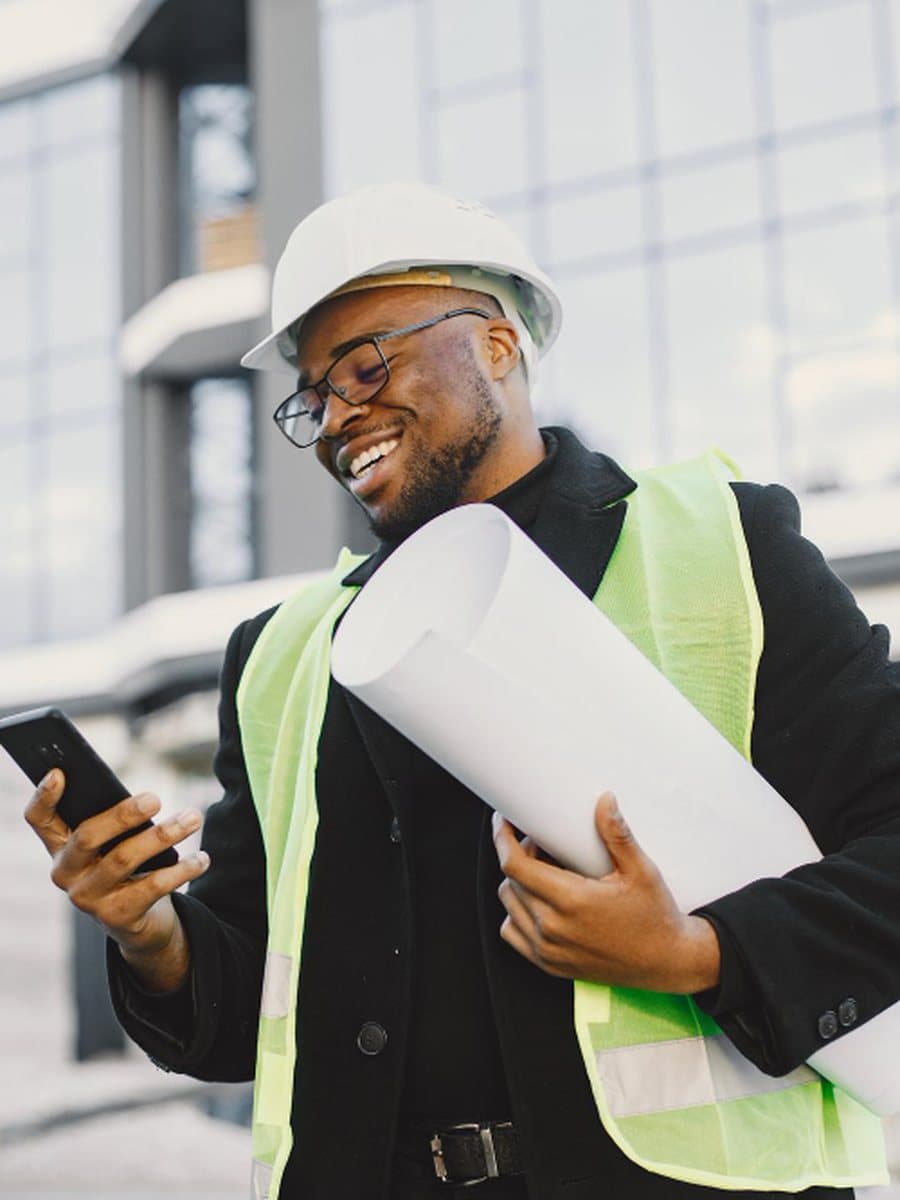 A project professional on site with drawings in hand